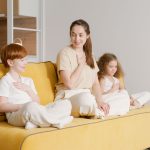 Mẹ hướng dẫn trẻ tập thở nhẹ trên ghế sofa